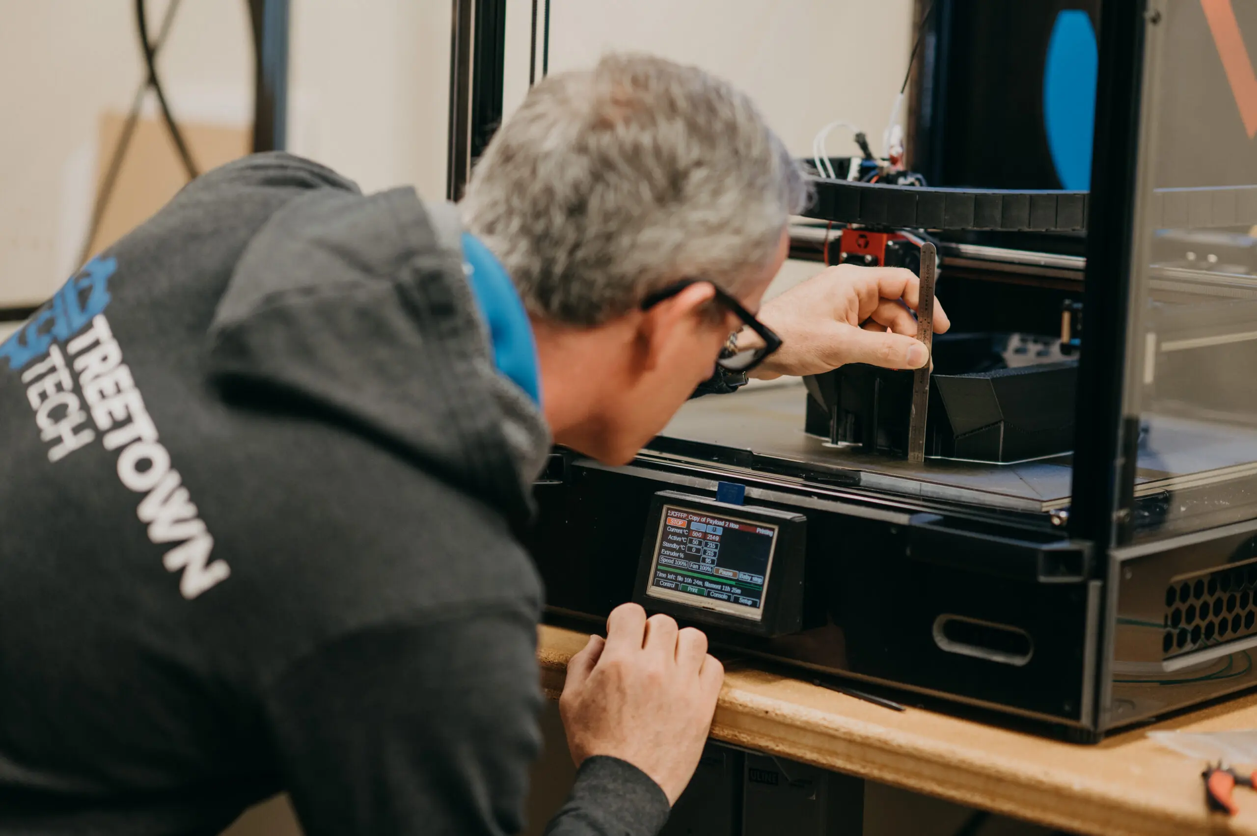 Treetown tech employee measuring a 3D printing project