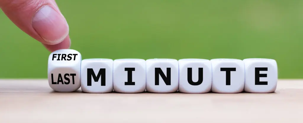 Hand turns a dice and changes the expression "first minute" to "last minute"