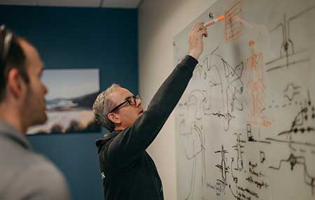two treetown tech employees working out a problem together on the white board