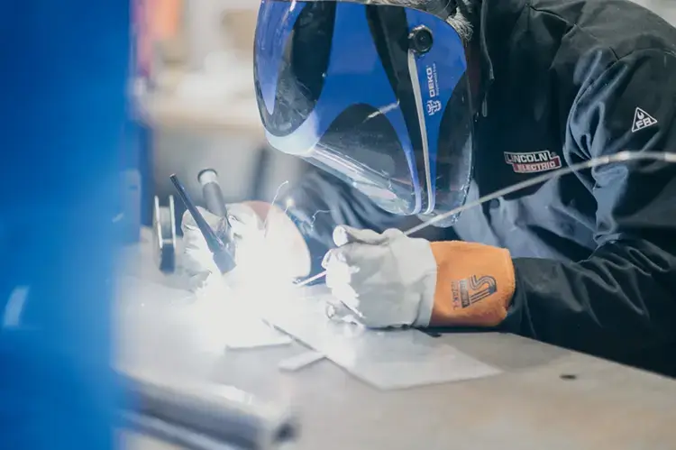 Treetown Tech employee welding metal