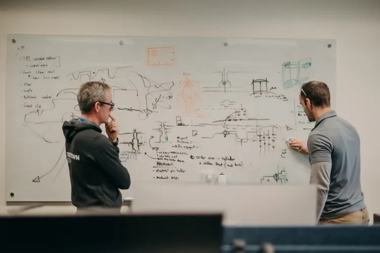 Treetown Tech employees discussing project and writing on a white board