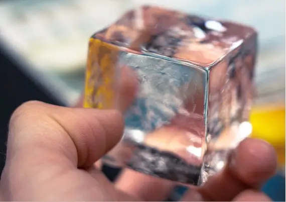 Hand holding an ice cube