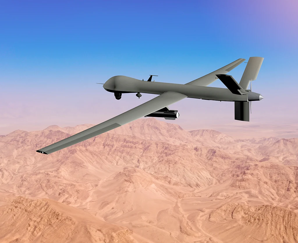 Military-grade fixed-wing UAV flying over desert terrain, illustrating Treetown Tech’s autonomous vehicle engineering and defense systems expertise